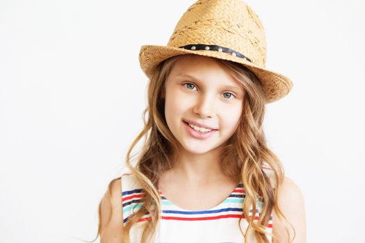 Closeup portrait of a lovely little girl with straw hat against a white background