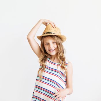 Closeup portrait of a lovely little girl with straw hat against a white background