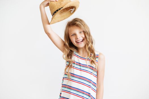 Closeup portrait of a lovely little girl with straw hat against a white background