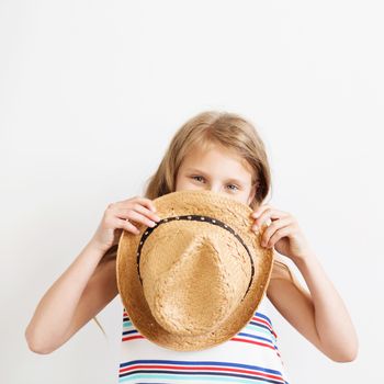 Lovely little girl with straw hat against a white background. Happy kids