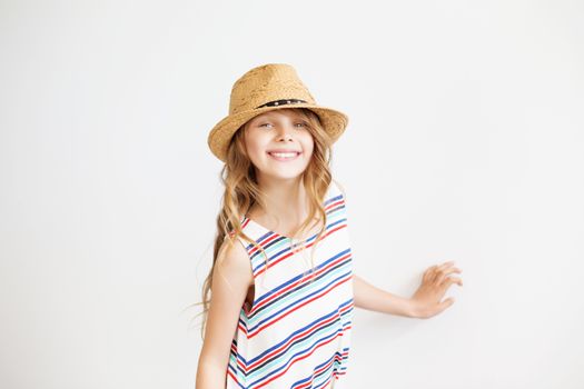 Lovely little girl with straw hat against a white background. Happy kids