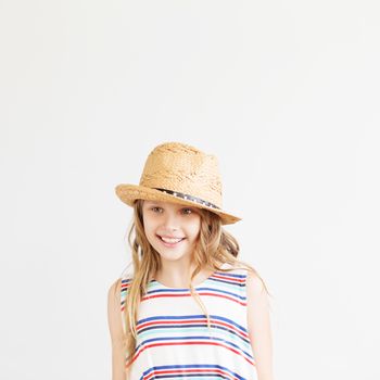 Lovely little girl with straw hat against a white background. Happy kids