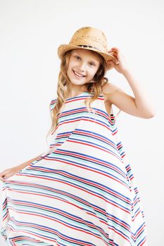 Lovely little girl in straw hat against a white background. Smiling summer kids