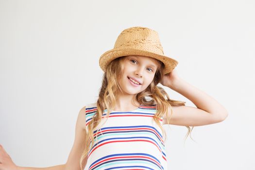 Lovely little girl with straw hat against a white background. Happy kids