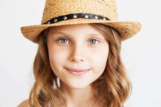 lovely little girl with straw hat against a white background. Closeup portrait of little girl wearing hat