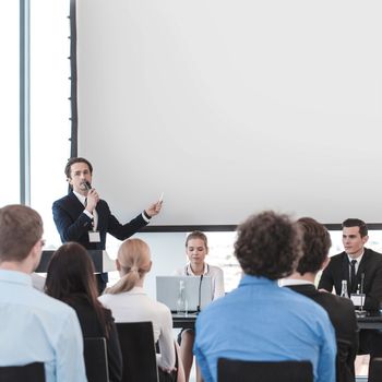 Business people speaking at presentation in microphone in office