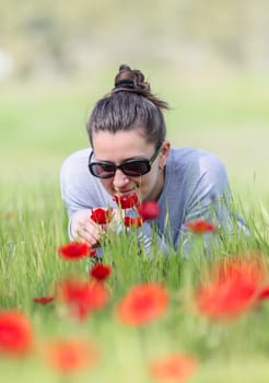 woman relaxing in a field with red poppies