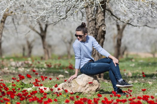 woman relaxing in a field with red poppies