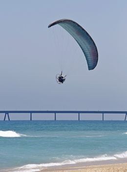 flying parachutist against the sea and blue sky