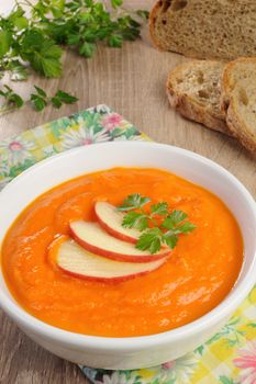 Plate of sweet pumpkin puree soup with apple