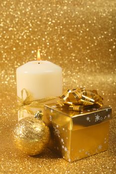 Beautiful christmas candle on golden glitter background with copy space