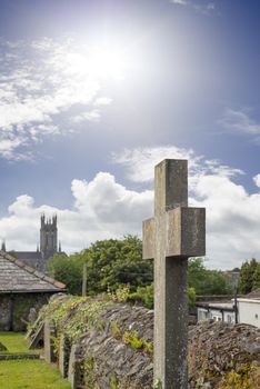 sunshine over cross at ancient graveyard in St Canice’s Cathedral in kilkenny city ireland