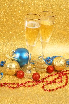 Champagne and christmas decor on golden glitter background with copy space