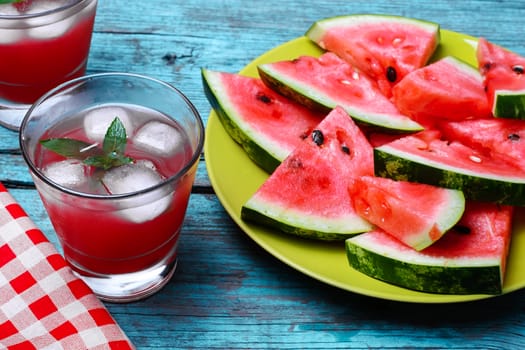 Fresh fruit of summer watermelon cut into lobes on plate on bright background
