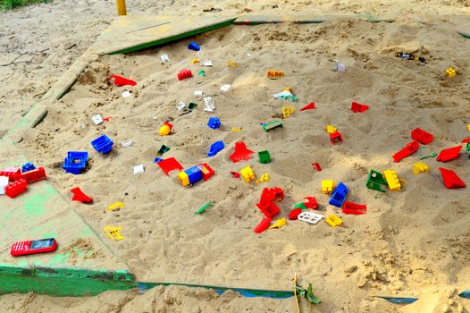Children's sandbox with toys scattered.