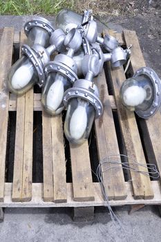 Used in the production of waste lamps are stacked on a wooden pallet on the floor.