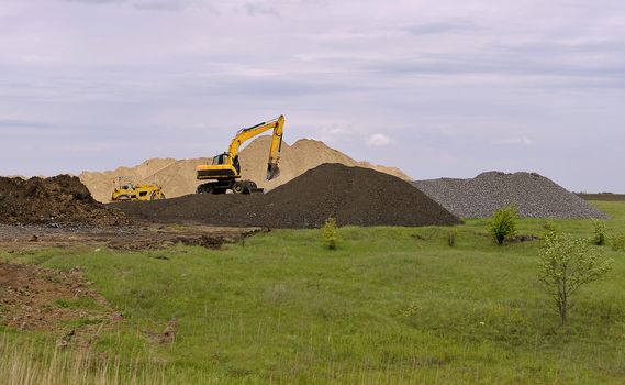  Yellow excavator working digging in sand quarry