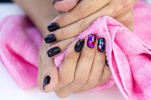 Drying hands girl with stylish manicure pink towel