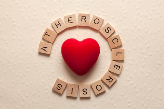 The word atherosclerosis formed with wooden letters and a heart in the middle