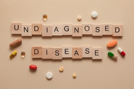 The word Undiagnosed disease formed with wooden letters and pills around