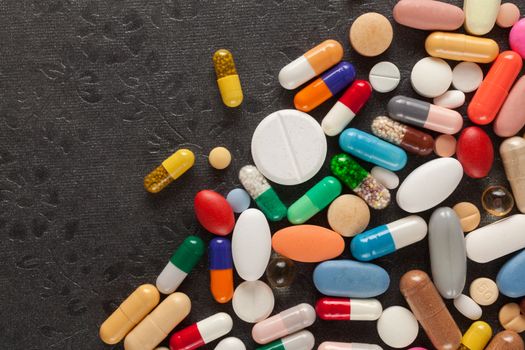 Colorful pills over dark background