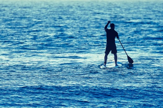 Man on Stand Up Paddle Board surrounded my sea water.