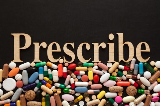 Word Prescribe with wooden letters on colorful pills