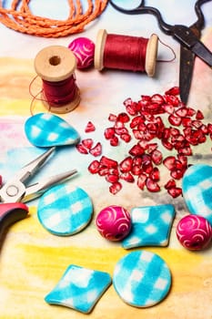 Varieties of beads for making jewelry on bright colored background