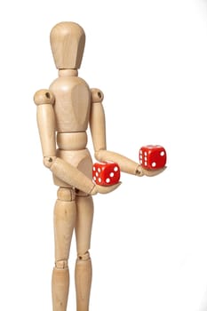 Wooden puppet holds dice on white background with clipping path