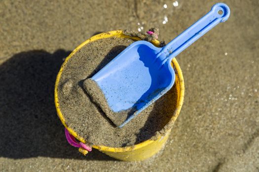 Toy Spade and Bucket on a Beach with sand.