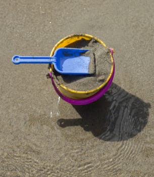 Toy Spade and Bucket on a Beach with sand.