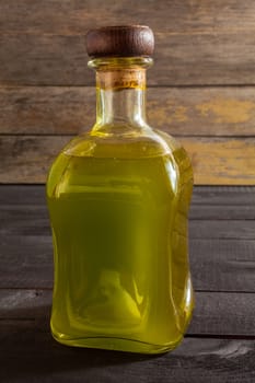 Olive oil bottle on wooden background