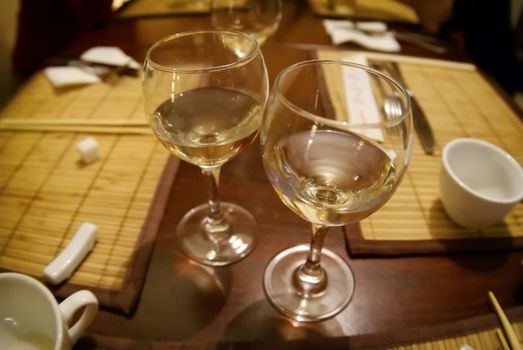 Two glasses of white wine on a restaurant table