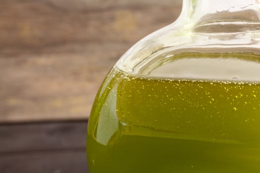 Olive oil bottle on wooden background
