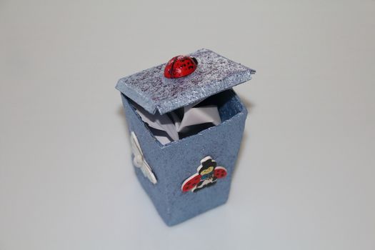 A small hand-made waste bins decoupaged with ladybug and butterfly, handmade objects decorated using different techniques of decoupage