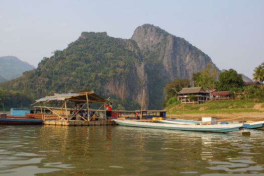 LUANG PRABANG DISTRICT, LAOS - FEBRUARY 15, 2016: People waiting on the Ferry during sunset on February 15, 2016 in the Luang Prabang district , Laos, Asia