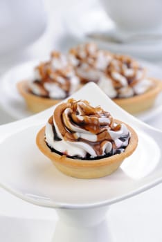 Shortbread сakes filled jam with whipped cream and chocolate, caramel topping