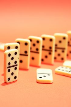 Black dominoes standing in a row on red background