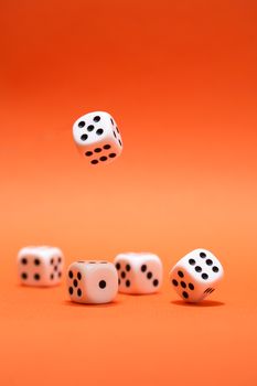 Dice game. One dice cube falling to another dices on red background