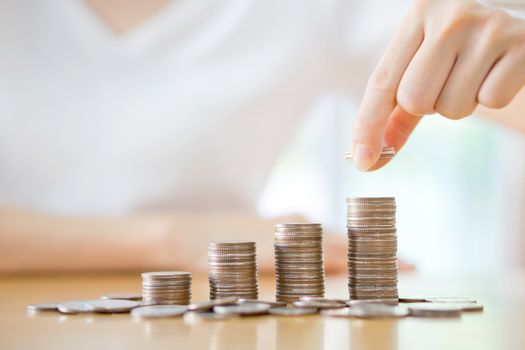 woman put coins to stack of coins
