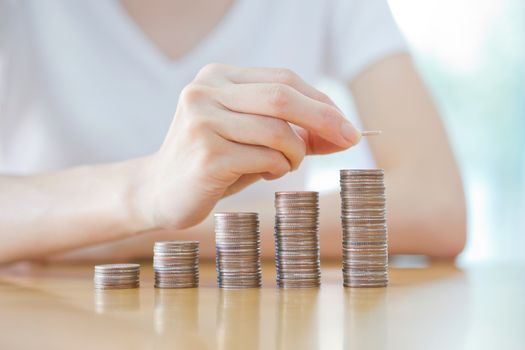 woman put coins to stack of coins