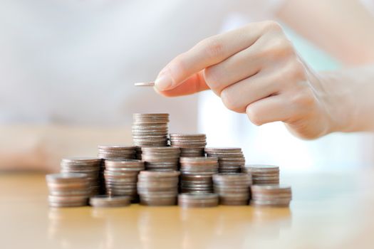 Hand put coins to stack of coins