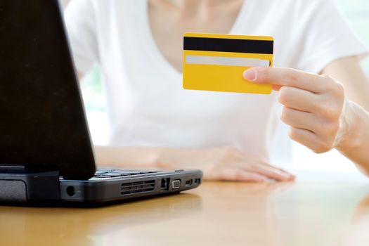 Hands holding credit card and using laptop. Online shopping