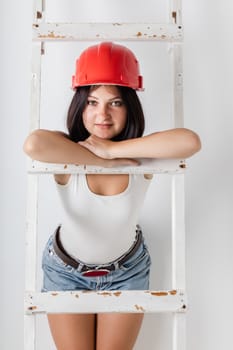 woman in the construction hardhat on a light background