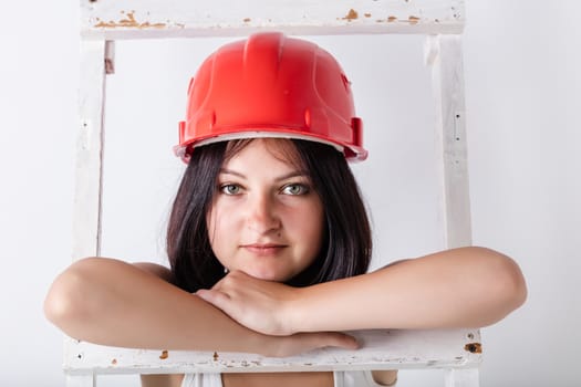 woman in the construction hardhat on a light background