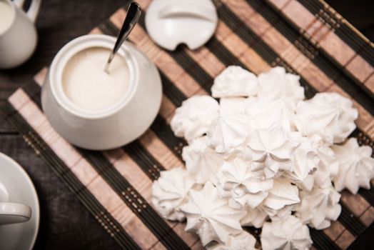 bizet on a brown wooden table with a cup of tea, sugar and milk