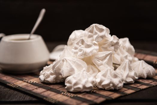 bizet on a brown wooden table with a cup of tea, sugar and milk