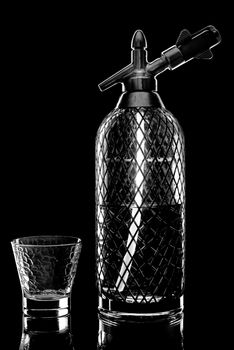 siphon with soda copulation on the table on a black background with an empty Cup