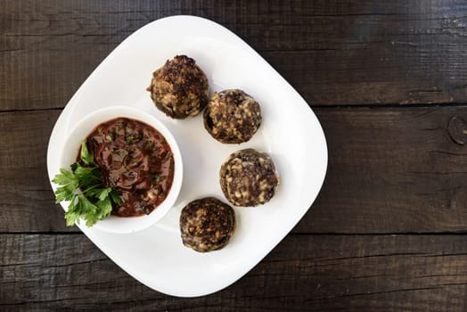 baked mushrooms with meat and sauce on a plate and wood