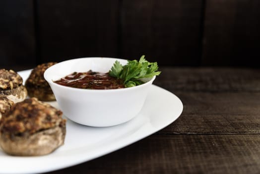 baked mushrooms with meat and sauce on a plate and wood